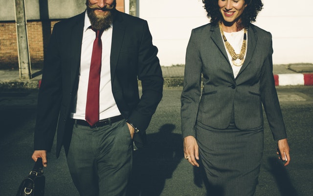 Two workers in business suits walking outside