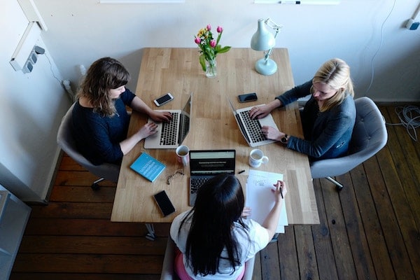 women at a conference table at work