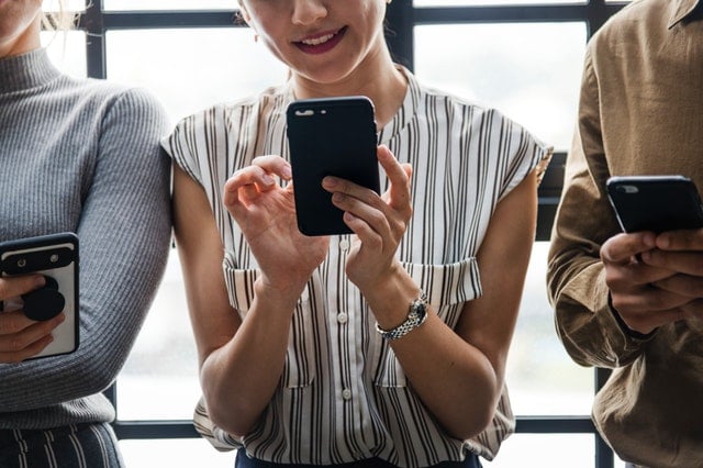 Woman using cellphone in a group