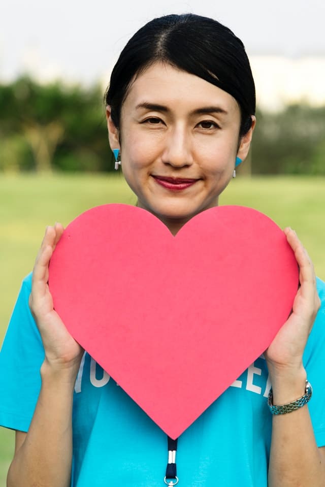 Volunteer holding a cut out heart