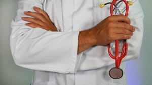 Doctor wearing a white coat holding a stethoscope 