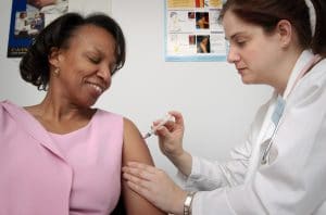 Woman getting vaccine from doctor